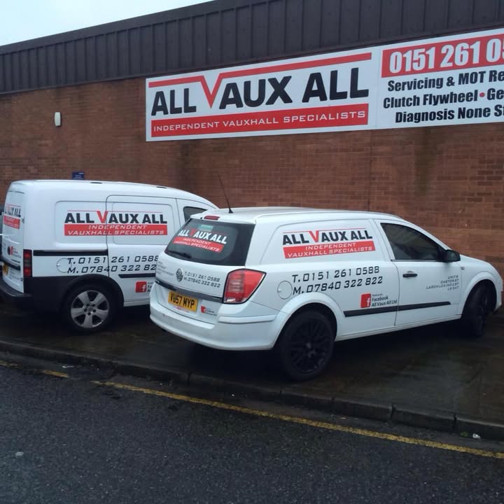 Two white All Vaux All vans parked under the Independent Vauxhall Specialists banner on the unit wall